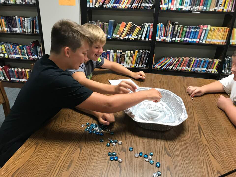 Students using marbles in experiment. 